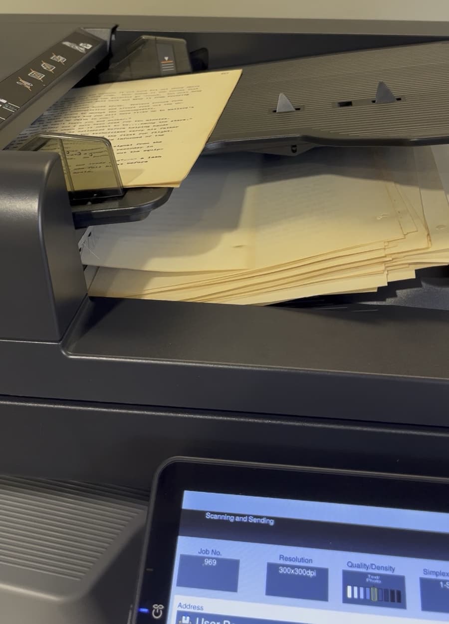 Typed manuscript pages feeding through a library copier set to scan at 300 dpi